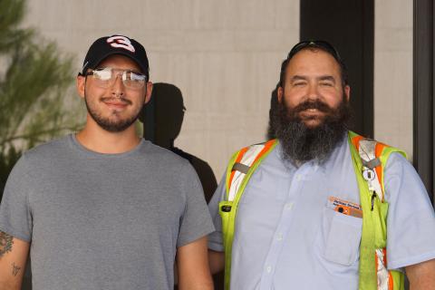 Trent Columbus (left), an SWR driver, and Jeff Alford, SWR supervisor, visit campus waste corrals on Trent’s first day at UT. The photo was taken at the LBJ Presidential Library.