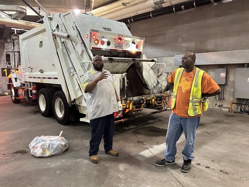 Milton Roberson Jr. (left), SWR team lead, and Tim Williams, an SWR worker, stand under the Darrell K Royal-Texas Memorial Stadium’s north loading docks, preparing for the next load of trash after a home football game. SWR crews work post-game Saturday and return on Sunday to complete the removal of all waste.